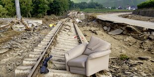 Auf kaputten Bahngleisen steht ein Sessel