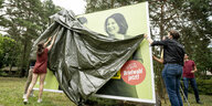 Ein grünees Wahlplakat wird enthüllt, man sieht einen Kopf von Annalena Baerbock
