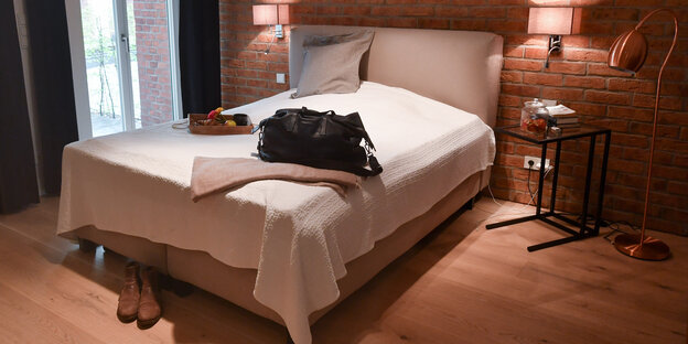 Eine Reisetasche ist in der Wohnung eines Airbnb-Gastgebers auf dem Bett im Schlafzimmer abgestellt