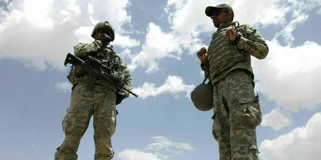 Ein US-Soldat und Dolmetscher gekleidet in Tarnmuster kommuniziert über Funk