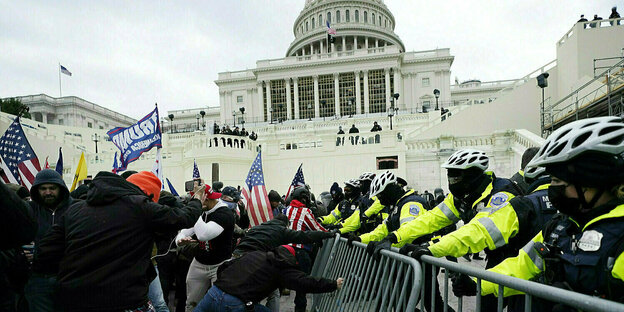 Demonstranten Polizeisperre am Kapitol in Washington zu durchbrechen, die Polizisten stehen auf der anderen Seite der Sperre und halten dagegen