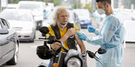 Ein Mann auf dem Motorrad wird geimpft