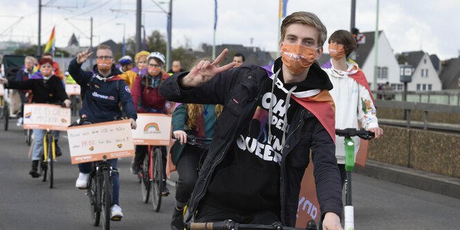 Fahrradfahrende mit Regenbogenmasken