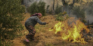 Eine Frau versucht, ein Feuer auszuschlagen
