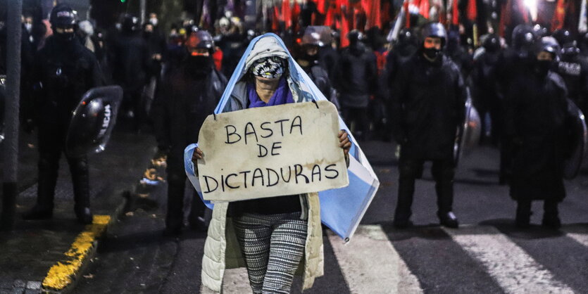 Eine Person bei Protesten mit einem Schild.