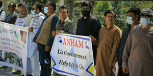Demonstrierende Afghanen bitten auf Transparent US-Regierung um Hilfe