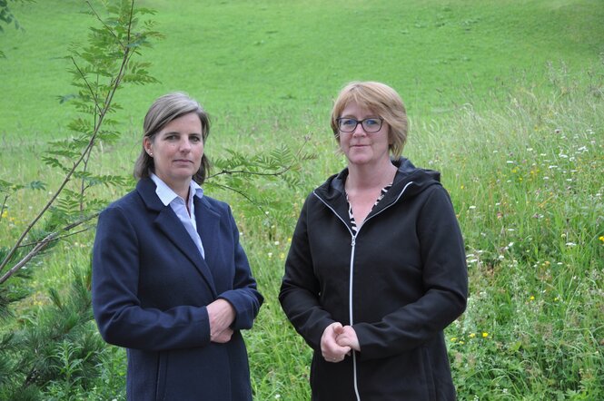 Zwei frauen in grüner Landschaft.