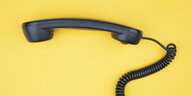 Ein Festnetztelefon vor gelbem Hintergrund.