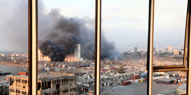 Ein brennendes Gebäude in einem Hafen.