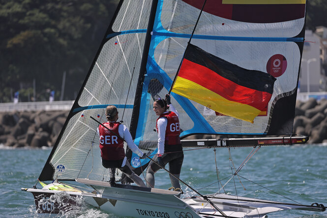 Die Seglerinnen Tina Lutz und Susann Beucke mit der Deutschlandfahne auf ihrem Boot