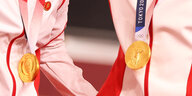Nahaufnahem der Trainingsanzüge der Goldmedaillengewinnerinen Bao Shanju und Zhong Tianshi mit einem Button, der Mao zeigt