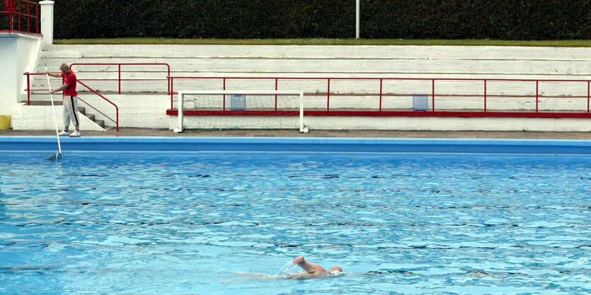 Während der Bademeister Schmutz aus dem Becken sammelt, zieht der einzige Badegast im Stadionbad in Bremen seine Bahnen.