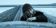 Szene aus „Der Atem des Meeres“: alter Mann auf einer Draisine im Wattenmeer