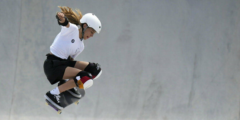 Lilly Stoephasius springt mit dem Skateboard