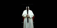 Papst Franziskus hält während Feierlichkeiten ein großes schwarzes Holzkreuz in die Höhe vor seinem Gesicht