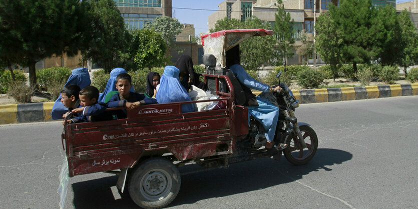 Menschen in einem Motoradtaxi.