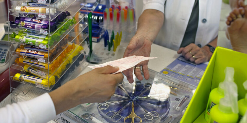 Patient überreicht Rezept in der Apotheke