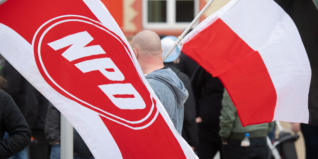 Mit wehenden Fahnen ziehen Anhänger der rechtsextremen NPD durch die Innenstadt von Greifswald.