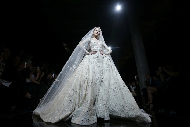 Ein Model trägt auf dem Laufsteg ein Hochzeitskleid