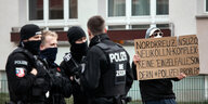 PolizistInnen schauen auf eine Person mit Schild: "Nordkreuz, NSU 2.0, Neukölln-Komplex - keine Einzelfälle, sondern # Polizeiproblem"