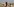 Verhüllte Frau mit 2 kleinen Kindern in wüster Landschaft vor wüstem Häusermeer
