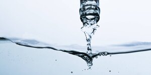 Der Hals einer Mineralwasserflascheund Wasser