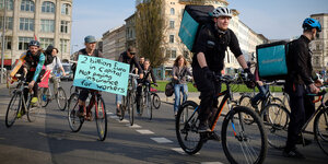 Menschen demonstrieren auf ihren Fahrrädern für bessere Arbeitsbedingungen bei Lieferdiensten