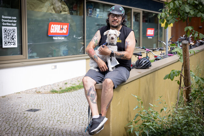 Portraitfoto von Fernando Bolarus, der einen Hund im Arm hält