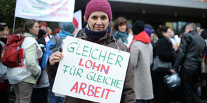 Altes Thema: eine Vivantes-Mitarbeiterin zeigt in Berlin vor dem Krankenhaus Friedrichshain ein Schild mit der Aufschrift "Gleicher Lohn für gleiche Arbeit", eine Aufnahme von 2016