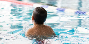 Ein Junge schwimmt in einem Schwimmbecken