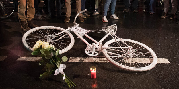 Weißes Fahrrad liegt auf dunkler Straße