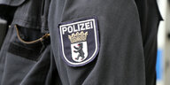 Eine Nahaufnahme eines Polizeiwappen auf einer Uniform eines Berliner Polizisten