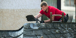 Ein Dachdecker arbeitet auf einem Dach
