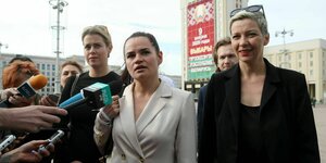 Drei Frauen auf einem Platz in Minsk, gegenüber Mikrofonen der Medien