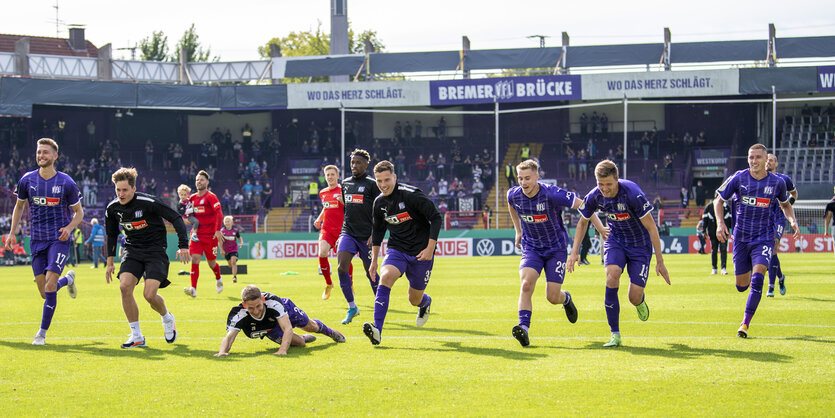 Spieler des Vfl Osnabrück laufen nach dem Spiel in Richtung Fan-Tribüne