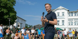 Christian Lindner mit einem Mikrophon auf einer Wahlkampfbühne