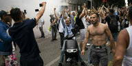 mehrere Menschen stehen auf einer Straße in Frankreich und klatschen in die Hände