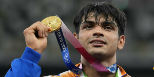 Neeraj Chopra hält seine Gold-Medaille in die Luft