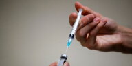 eine Spritze wird mit dem Impfstoff von biontech aufgezogen