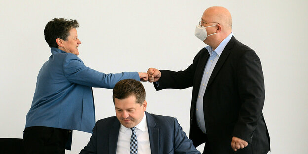 Lydia Hüskens, FDP, und Andreas Schmidt (r), SPD begrüßen sich hinter Sven Schulze, CDU