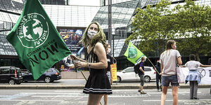 Junge Frau hält eine Flagge mit der Aufschrift Fridays for Future