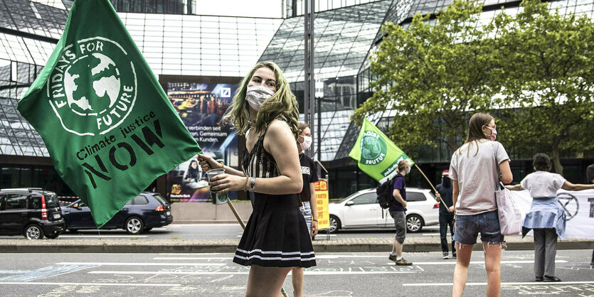 Junge Frau hält eine Flagge mit der Aufschrift Fridays for Future