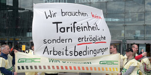 Demonstranten protestieren mit einem großen Transparent: "Wir brauchen keine Tarifeinheit, sondern erträgliche Arbeitsbedingungen."