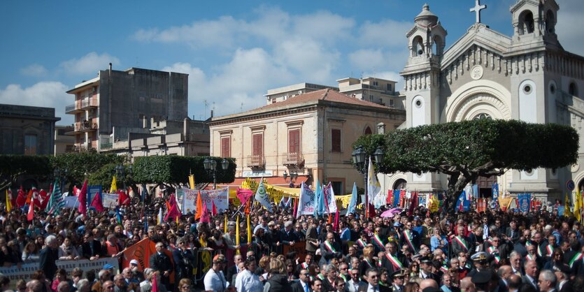 Menschenmenge und Protestplakate vor einer Kirche