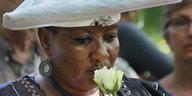 Eine Frau hält eine Blume vor ihrem Gesicht