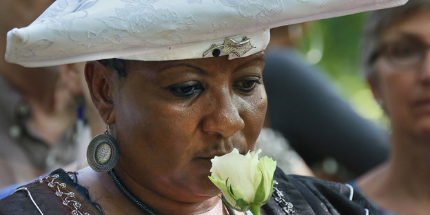 Eine Frau hält eine Blume vor ihrem Gesicht