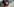 Eine Person mit Liefer-Rucksack von hinten, im Hintergrund Fahrräder