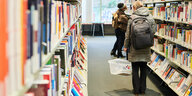 Zwei Besucherinnen stehen zwischen Bücherregalen in der Zentral- und Landesbibliothek Berlin (ZLB/ Amerika-Gedenkbibliothek)