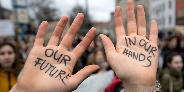 Eine Schülerin zeigt während der Demo "Fridays for Future" im Zentrum von Halle/Saale ihre Hände mit der Aufschrift "Our future in our hands"