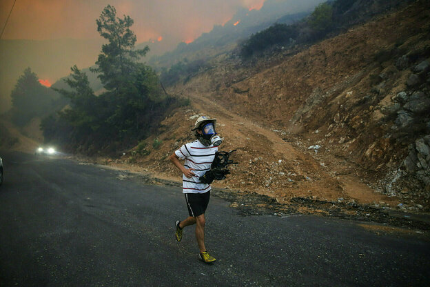 Ein Mann läuft auf eine Strasse und trägt eine Gasmaske, ein Auto naht, im Hintergrund lodern Waldbrände